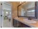 Bathroom with double sinks, dark wood vanity, and view into the bedroom and separate shower at 9274 Viaggio Way, Highlands Ranch, CO 80126