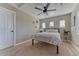 Cozy bedroom with neutral walls, carpet flooring, and a metal frame bed by three small windows at 9274 Viaggio Way, Highlands Ranch, CO 80126