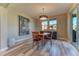 Inviting dining room features a round wood table, modern light fixture and sliding glass door at 9274 Viaggio Way, Highlands Ranch, CO 80126