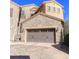 Stone clad exterior with two car garage and brick paver driveway at 9274 Viaggio Way, Highlands Ranch, CO 80126