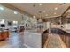 Open-concept kitchen with dark wood cabinets, granite island, and adjacent living room with fireplace at 9274 Viaggio Way, Highlands Ranch, CO 80126