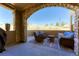 Covered outdoor patio with stone archway features comfortable seating with views at 9274 Viaggio Way, Highlands Ranch, CO 80126