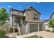 View of the front of the home showing the porch, front door and two car garage at 5153 Andes Way, Denver, CO 80249