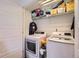 Convenient laundry room featuring a washer and dryer, a shelf for storage, and white painted cabinets at 5153 Andes Way, Denver, CO 80249