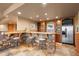 Basement bar featuring stone accents, seating for three, and stainless steel refrigerator at 19155 Lochmere Ct, Monument, CO 80132