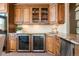 Wet bar with custom cabinets, granite counters, sink, dual zone wine coolers and stone accents at 19155 Lochmere Ct, Monument, CO 80132