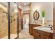 Bathroom boasting dual sinks, granite counters, and a glass-enclosed tile shower at 19155 Lochmere Ct, Monument, CO 80132