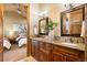 Primary bath featuring dual sinks, granite counters, and an inviting doorway to the bedroom at 19155 Lochmere Ct, Monument, CO 80132