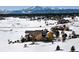 A sprawling home nestled in a snow-covered landscape with majestic mountain views in the distance at 19155 Lochmere Ct, Monument, CO 80132