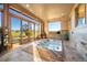 Bright and airy indoor hot tub room with large windows and stone accents, offering scenic views at 19155 Lochmere Ct, Monument, CO 80132