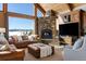 Cozy living room features a stone fireplace, vaulted ceilings, large windows with snow capped mountain views at 19155 Lochmere Ct, Monument, CO 80132