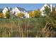 Exterior view of the community with grassy lawn, mature trees and a pond in the foreground at 6380 S Boston St # 191, Greenwood Village, CO 80111