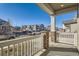 Covered front porch with white railing, brick pillars, and view of neighborhood at 4847 Astor Pl, Brighton, CO 80601