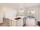 Kitchen island with sink and stainless steel dishwasher, opens to backyard at 4847 Astor Pl, Brighton, CO 80601