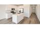 Modern kitchen with white cabinets, island, and stainless steel appliances at 4847 Astor Pl, Brighton, CO 80601