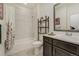 Stylish bathroom features a shower-tub combo with tile surround and dark vanity at 25019 E Alder Dr, Aurora, CO 80016