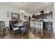 Open dining area with dark wood floors leading to the bar and kitchen, with a chandelier at 25019 E Alder Dr, Aurora, CO 80016