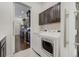 Laundry room with dark cabinets and stainless steel washer and dryer at 25019 E Alder Dr, Aurora, CO 80016