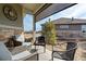 Covered patio featuring stone trim, elegant seating area, and an outdoor view at 25019 E Alder Dr, Aurora, CO 80016