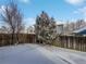 Snowy backyard with a wooden fence and trees at 4578 Malta St, Denver, CO 80249