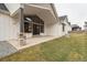 A covered patio extends from this home into a backyard that features a manicured lawn and rock features at 1361 Art Dr, Berthoud, CO 80513