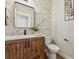 Powder room featuring a decorative mirror and a wood vanity with marble counters at 1361 Art Dr, Berthoud, CO 80513
