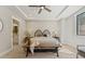 Bright bedroom featuring a ceiling fan, tray ceiling, bench and neutral color palette at 1361 Art Dr, Berthoud, CO 80513