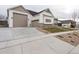 View of the home with a three-car garage and newly landscaped front yard with modern design elements at 1361 Art Dr, Berthoud, CO 80513