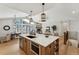 Modern kitchen island with marble countertops, wooden accents, and open design to dining and living spaces at 1361 Art Dr, Berthoud, CO 80513