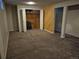 Finished basement with a large closet, wood accent wall, and carpet, offering potential for customization at 5171 S Quintero St, Centennial, CO 80015