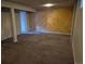 Finished basement features include carpeted flooring, wood accent wall, and support beams at 5171 S Quintero St, Centennial, CO 80015