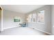 Sunlit bedroom featuring large windows, a cozy armchair, and neutral carpeting at 8041 E 29Th Ave, Denver, CO 80238