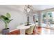 A sun-filled dining room features wood floors, modern lighting, and access to the outdoor living space at 8041 E 29Th Ave, Denver, CO 80238