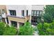 Modern townhouse with large windows, balcony, and cozy patio surrounded by lush greenery at 8041 E 29Th Ave, Denver, CO 80238