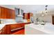 This modern kitchen features cherry cabinets, white quartz counters, a gas range, and stainless steel appliances at 8041 E 29Th Ave, Denver, CO 80238