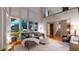 Bright living room with soaring ceilings, large windows, hardwood floors and modern gray sofa at 8041 E 29Th Ave, Denver, CO 80238