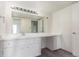 Bathroom with a large vanity area, mirror, and bright lighting at 9725 E Harvard Ave # 317, Denver, CO 80231