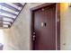Brown apartment entry door featuring a code pad, lock, and stairs nearby at 9725 E Harvard Ave # 317, Denver, CO 80231