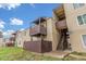Tan apartment building featuring wood balconies and stairwell in outdoor setting at 9725 E Harvard Ave # 317, Denver, CO 80231