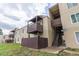Tan apartment building featuring wood balconies and stairwell in outdoor setting at 9725 E Harvard Ave # 317, Denver, CO 80231
