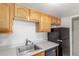 Bright kitchen features natural wood cabinets, laminate countertops and a stainless steel sink at 9725 E Harvard Ave # 317, Denver, CO 80231