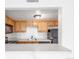Kitchen featuring wood cabinets, black appliances, and a pass-through at 9725 E Harvard Ave # 317, Denver, CO 80231