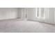 Spacious living room with neutral carpeting, white walls, and sliding glass door at 9725 E Harvard Ave # 317, Denver, CO 80231