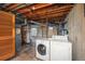 Unfinished basement area with exposed ceiling, utility access and laundry hookups including a washer and dryer at 7121 E Arkansas Ave, Denver, CO 80224
