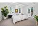 Bright bedroom with white walls, carpet, two arched windows, and a door to the outside deck at 7121 E Arkansas Ave, Denver, CO 80224