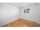 Bright bedroom with hardwood floors and a window, showcasing a minimalist design at 7121 E Arkansas Ave, Denver, CO 80224