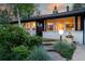 Charming single-story home with brick exterior, inviting entry, manicured landscaping, and warm exterior lighting at 7121 E Arkansas Ave, Denver, CO 80224