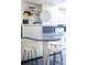 Kitchen featuring breakfast bar, open shelving, white cabinets and view of gas range at 7121 E Arkansas Ave, Denver, CO 80224