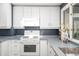 Bright kitchen with white cabinets, gray countertops, and modern appliances offers a clean design at 7121 E Arkansas Ave, Denver, CO 80224