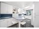 Bright kitchen featuring white cabinetry, a skylight, sleek countertops, and a central island with seating at 7121 E Arkansas Ave, Denver, CO 80224